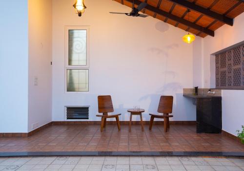 a living room with two chairs and a table at Sarvam Serviced Apartment in Coimbatore