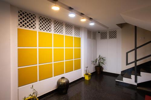 a room with yellow and white walls and a vase at Sarvam Serviced Apartment in Coimbatore