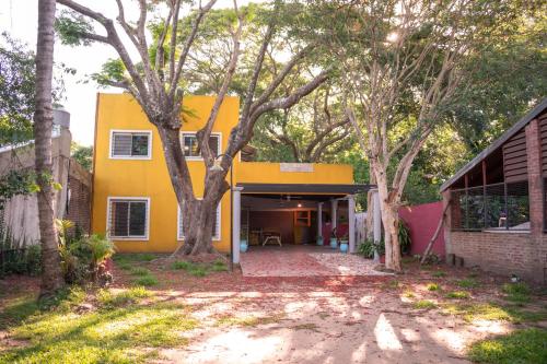 a yellow house with trees in front of it at Casa Paso de la Patria in Corrientes