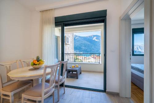 a dining room with a table and a balcony at Boka View Luxury Suite - With free Garage Parking in Kotor
