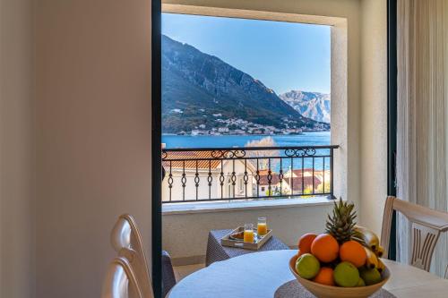uma sala com uma mesa com uma tigela de fruta em Boka View Luxury Suite - With free Garage Parking em Kotor