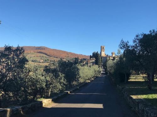 a road with trees and a building on a hill at Il Fiorino di Badia in Badia A Passignano