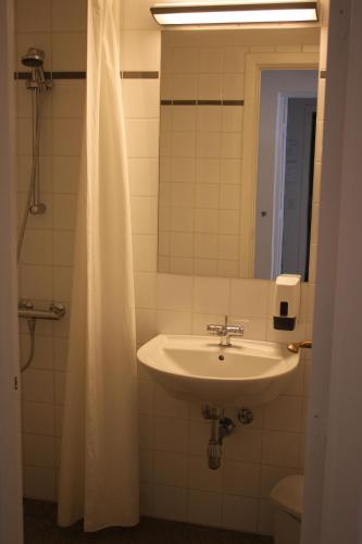 a bathroom with a sink and a mirror at Skarrildhus Sinatur Hotel & Konference in Skarrild