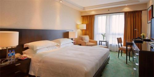 a hotel room with a large bed and a desk at Guo Ji Yi Yuan Hotel in Beijing