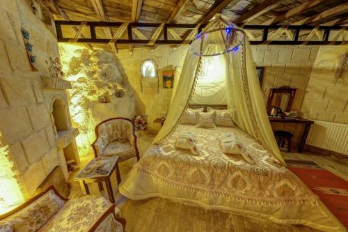 a bedroom with a bed with a canopy at Cappadocia Alaz Cave Otel in Nevşehir