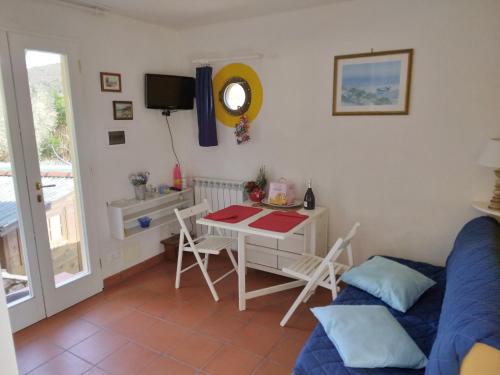 ein Wohnzimmer mit einem Tisch und einem Sofa in der Unterkunft Felciaio in Capoliveri
