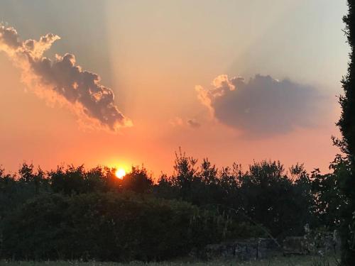 a sunset with the sun setting in the sky at Il Fiorino di Badia in Badia A Passignano