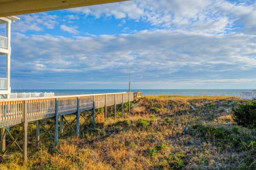 a house on a beach with the ocean in the background at Beachy Keen in Holden Beach