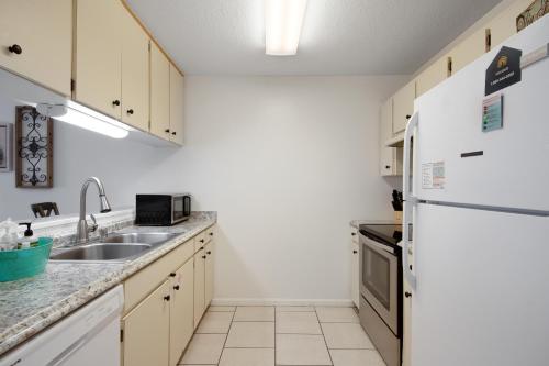 a kitchen with a sink and a refrigerator at Blue Shores in Panama City Beach