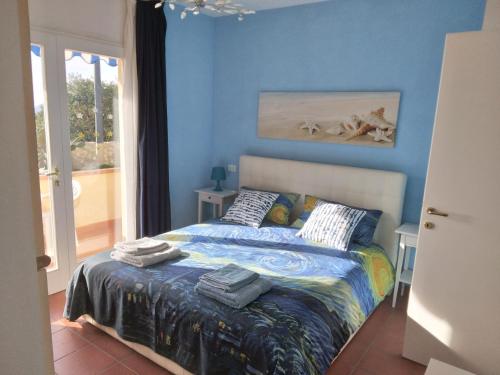 a bedroom with a bed with a blue wall at Felciaio in Capoliveri