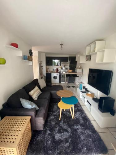 uma sala de estar com um sofá e uma mesa em Logement entier T2 climatisé, parking gratuit, jardin, mer em Sanary-sur-Mer