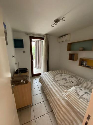 um quarto com uma cama e uma janela em Logement entier T2 climatisé, parking gratuit, jardin, mer em Sanary-sur-Mer