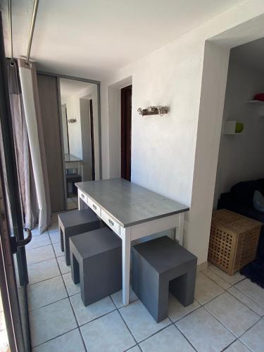 uma mesa e alguns bancos numa sala em Logement entier T2 climatisé, parking gratuit, jardin, mer em Sanary-sur-Mer