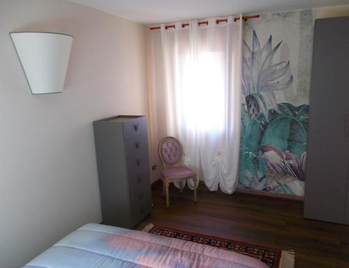 a bedroom with a bed and a window and a chair at Residenza San Felice in Vicenza