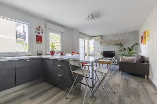 une cuisine et une salle à manger avec une table et des chaises dans l'établissement Superbe Appt Port Marianne, Parking Privé, 4 personnes, à Montpellier
