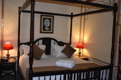 1 dormitorio con 1 cama con dosel y 2 lámparas en Hotel Nawal Sagar Palace - Bundi, en Bundi