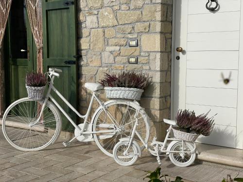 zwei Fahrräder, die vor einem Haus geparkt sind, mit Blumen in Körben in der Unterkunft CHALET VELA Natura e Relax in Gavardo