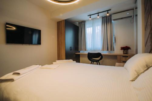 a bedroom with a large white bed and a desk at Central Apartment Chunarot in Ohrid