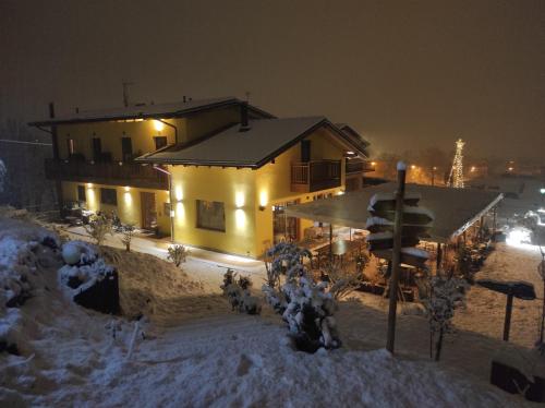 uma casa na neve à noite em Agriturismo La Soglia Del Parco em Ranica
