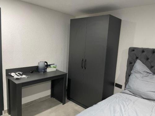 a bedroom with a black cabinet next to a bed at All In in Oberhausen