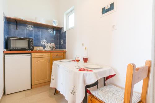 a small kitchen with a table with two glasses of wine at Vlassis Studios in Mesongi