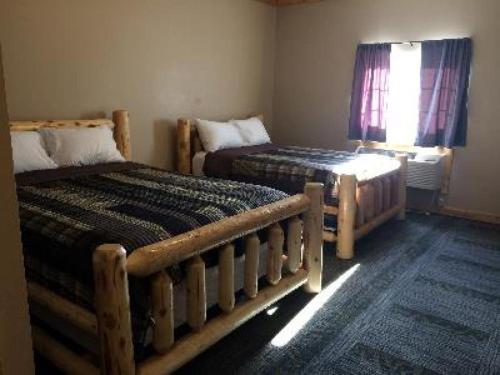 Lewistown的住宿－Big Horse Inn and Suites，一间卧室设有两张床和窗户。