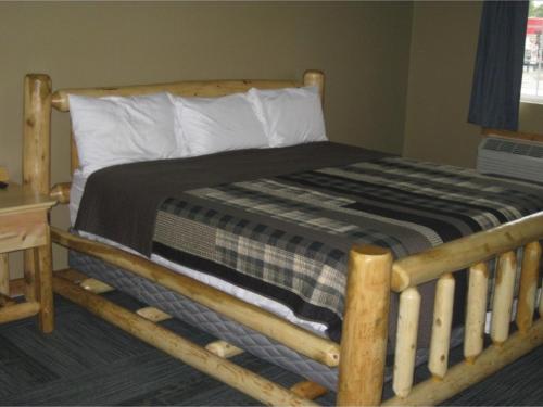 uma cama de madeira com um cobertor preto e branco em Big Horse Inn and Suites em Lewistown