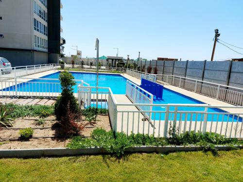 a swimming pool with blue water in a building at Arriendo Diario en Alto Serena V in La Serena