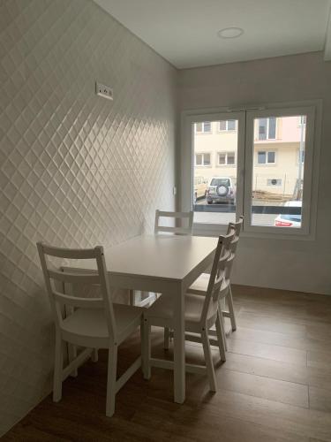 a dining room with a table and chairs and a window at Art'Estrela in Covilhã