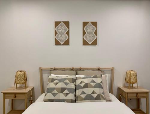 a bedroom with a bed with two chairs and two pictures on the wall at Art'Estrela in Covilhã
