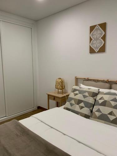 a bedroom with a bed with a window and a chair at Art'Estrela in Covilhã