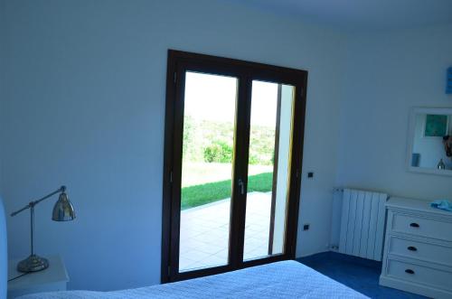 a bedroom with a door leading to a patio at Villa Smeralda in Palau