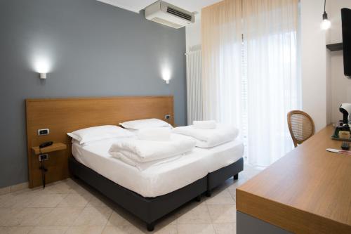 a bedroom with a bed with white pillows on it at Hotel Garden in Levanto