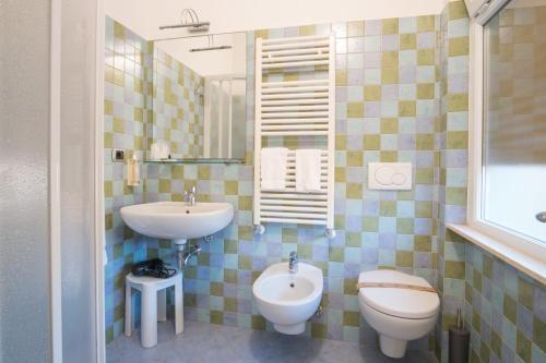 a bathroom with a sink and a toilet and a mirror at Hotel Garden in Levanto
