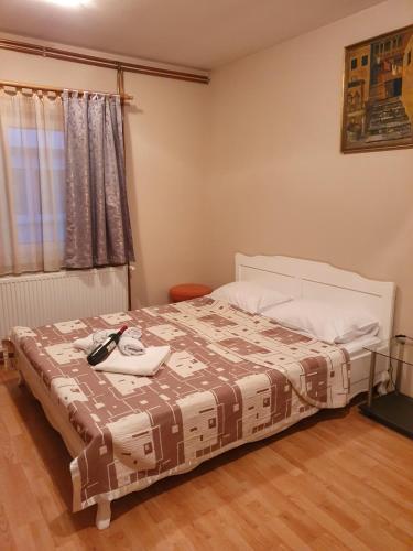 a bedroom with a bed with a phone on it at Apartman "MILLAN 2" in Prijedor