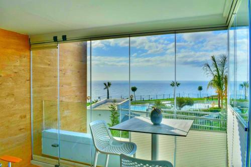 a balcony with a table and chairs and a view of the ocean at SUNNY BEACH APARTMENT IN CALACEITE in Torrox Costa