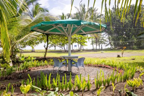 a table and two chairs under an umbrella at Hotel Tortuguero Beachfront in Tortuguero