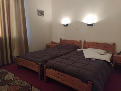 a bedroom with two beds and two lights on the wall at Apollon inn in Arachova