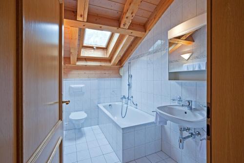 La salle de bains est pourvue d'un lavabo, d'une baignoire et de toilettes. dans l'établissement Les Naturelles, à Loèche-les-Bains