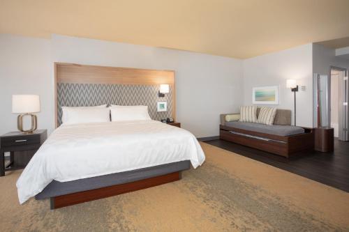 a large bedroom with a large bed and a couch at Holiday Inn Winchester Southeast-Historic Gateway by IHG in Winchester