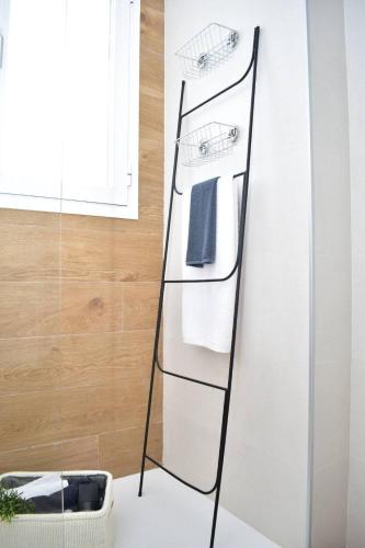 a black towel rack with towels on a wall at SUNNY BEACH APARTMENT IN CALACEITE in Torrox Costa