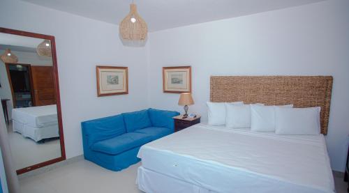 a bedroom with a bed and a blue couch at Arraial Bangalô Praia Hotel in Arraial d'Ajuda