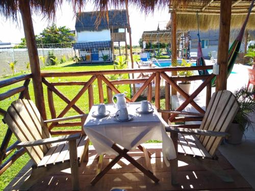 a table and chairs on a porch with a view of a pool at Camping y Cabañas Chelem in Chelem