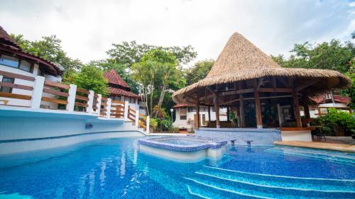 una piscina en un complejo con una cabaña en Hotel Luna Llena, en Tamarindo