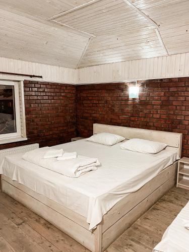 a large bed in a room with a brick wall at Guest House Lviv in Lviv