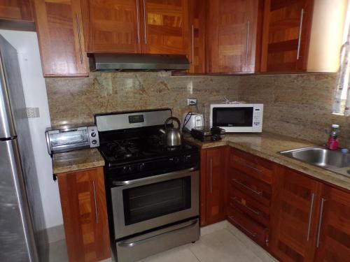 a kitchen with wooden cabinets and a stove top oven at Luxury in the Caribbean in Sosúa