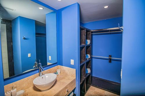 a blue bathroom with a sink and a mirror at THE BLUE APARTMENT in Puerto Vallarta
