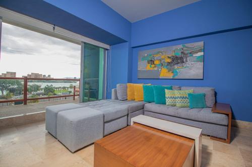 a living room with a couch and a large window at THE BLUE APARTMENT in Puerto Vallarta