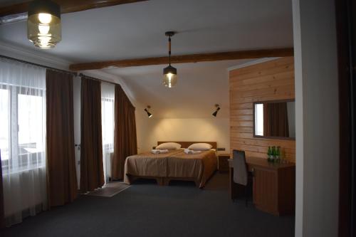 a bedroom with a bed in a room with windows at Князів Двір in Bukovel