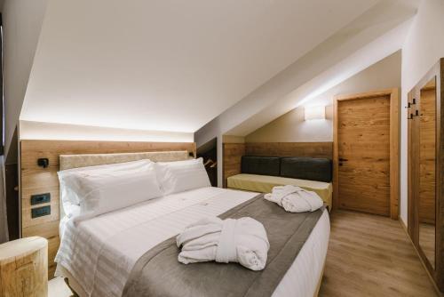 una camera da letto con due asciugamani su un letto di Chalet Queen a Canazei